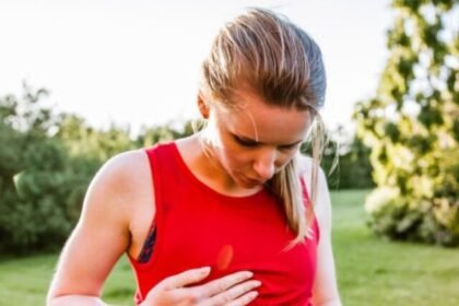Sporty woman outdoors, holding her stomach in pain